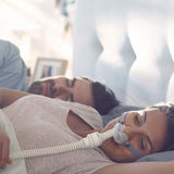 Photograph of a woman sleeping while wearing the AirFit P10 for AirMini nasal pillow mask