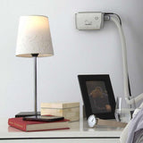 AirMini held on a wall above a nightstand, keeping the machine off the table surface