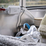 AirMini mounted on a ledge beside a window with a mask resting on the blanket below