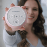 A woman holds the Transcend Micro 510 in Petal Pink in one hand, its four buttons facing the camera