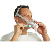 Man wearing the ResMed AirFit F30 full face CPAP mask and adjusting the headgear straps