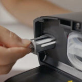 Close-up of a hand inserting a CPAP reusable foam filter into a DreamStation 2 style machine's filter compartment