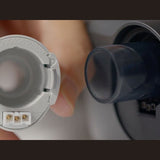 Photograph of a hand holding the machine cuff beside the humidifier outlet, close detail view