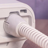 Photograph of the heated tube attached to a CPAP device on a bedside table