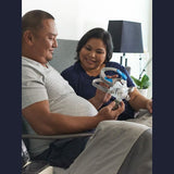 Couple sitting in bed together looking at a ResMed AirFit F30 full face CPAP mask