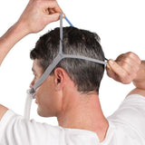 Photograph of a man wearing the AirFit P10 and spreading the split straps apart behind his head