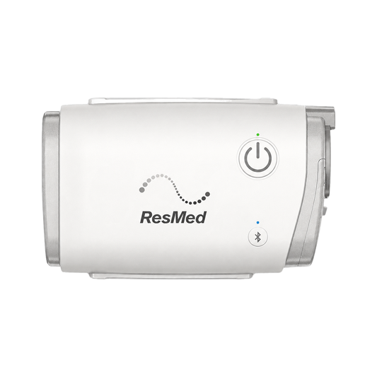ResMed AirMini travel CPAP machine on a white background, power button and Bluetooth indicator visible