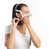 Woman wearing the AirTouch N20 For Her and adjusting the lower straps, with the lavender clip visible
