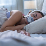 Photograph of a woman asleep on her side wearing the AirTouch F30i, the frame curving up over her head