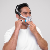 Photograph of a man fitting the AirTouch F40, the cushion under his nose and a magnetic clip in his hand