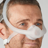 Photograph of the Philips DreamWisp mask resting on a nightstand beside a CPAP machine