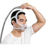 Photograph of a man wearing the AirFit F30i with one hand on the quick-release elbow above his head
