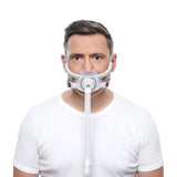 Photograph of a man wearing the AirFit F40, the cushion over his nose and mouth and the tube hanging down