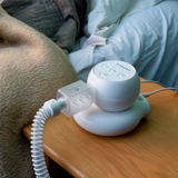The Transcend Micro on a bedside table, sitting on the PowerAway battery, sold separately, with the muffler and hose attached